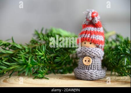 Weihnachtskarte Motiv kleine Puppe vor Kiefernzweigen Stockfoto