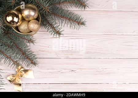 Stilvoller Eimer Weihnachten Golden Spielzeug auf einem weißen Holz Hintergrund und Zweige von Weihnachtsbäumen Stockfoto