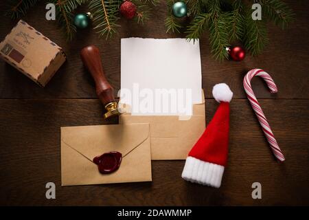 Leere Wunschliste für Weihnachtsmann auf Holztisch mit Weihnachtsschmuck. Draufsicht. Stockfoto