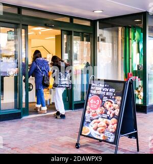 London, Großbritannien, November 15 2020, zwei junge Frauen betreten Mark und Spencer Chain Store während Covid-19 Coronavirus Lockdown Stockfoto