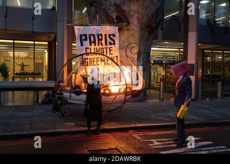 Klimaaktivisten mit der Rebellion des Aussterbens zünden ein "Wikingerschiff" außerhalb der National Maritime Organisation an, einen Tag vor dem virtuellen Gipfel des NMO-Komitees für Meeresumwelt am 15. November 2020 in London, England. Stockfoto