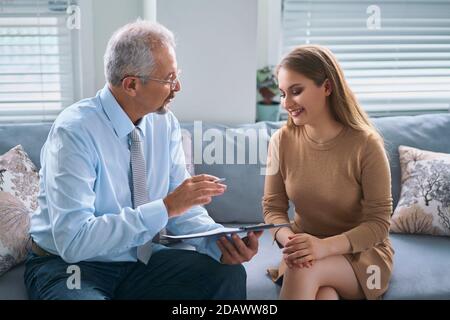 Junge Frau bei einer Beratung mit einem Psychotherapeuten. Die Psychologin hat mit ihrem Patienten im Büro zu einer Sitzung, die ihm Ratschläge zu seinem Leben gibt Stockfoto