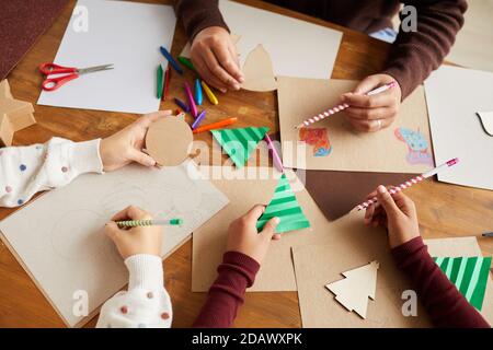 Oben sehen Nahaufnahme von Kindern, die während Kunst und Handwerk Klasse in der Schule Bilder zeichnen, Kopierraum Stockfoto