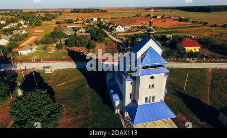 Schöne herbstliche ländliche Landschaft mit einer Kirche im Vordergrund. Luftaufnahme. Stockfoto