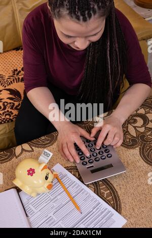 Das erste eingesparte Geld, auch das kleinste, gibt Anlass, glücklich und stolz zu sein. Ein junger Erwachsener spart erfolgreich und investiert das verdiente Geld. Stockfoto