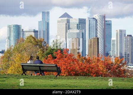 Junges Paar, das den Blick auf Canary Wharf vom Greenwich Park in London, England, Vereinigtes Königreich, UK genießt Stockfoto