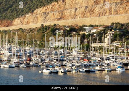 Ein Pier mit Yachten an der Küste während des Sonnenuntergangs. Yacht Club mit vielen Segelyachten in der Türkei angedockt. Stockfoto