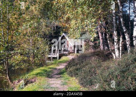 Landgraaf, Niederlande, 26. Oktober 2019: Kleines Holzhaus mit Floß am Ufer des Parks Mondo Verde Stockfoto