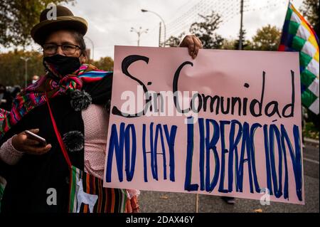 Madrid, Spanien. November 2020. Eine Frau in traditioneller Kleidung mit einem Plakat mit der Aufschrift "ohne Gemeinschaft gibt es keine Befreiung" während eines Protestes gegen Rassismus und Fremdenfeindlichkeit. Quelle: Marcos del Mazo/Alamy Live News Stockfoto