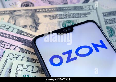 Stafford / Vereinigtes Königreich - November 15 2020: Ozon E-Commerce-Unternehmen Logo auf dem Bildschirm des Smartphones gesehen, auf Dollar-Scheine platziert. Konzept für INI