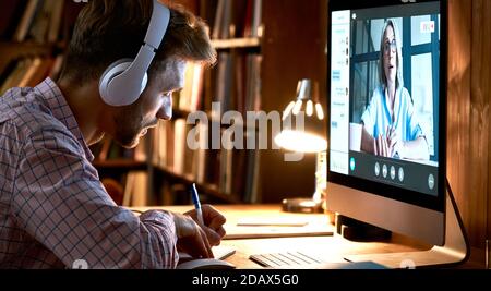 Männlicher Student mit Kopfhörern, Videokonferenz, Webinar ansehen. Stockfoto