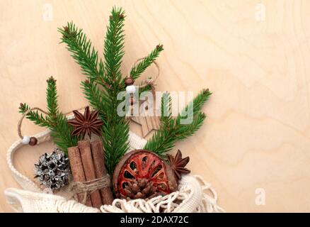 Fichtenzweig in einer umweltfreundlichen Papiertüte und Weihnachtsdekorationen auf Holzhintergrund. Sortiment von gemütlichen Hygge Weihnachten. DIY, Zero Waste, Öko Stockfoto