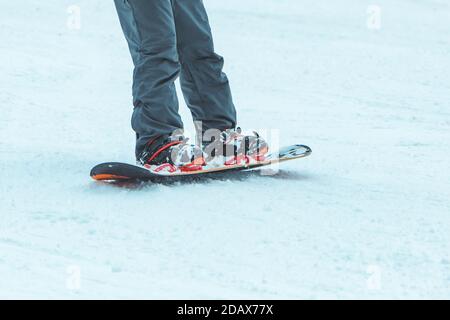 Mann Beine auf Snowboard Nahaufnahme. Crop Stockfoto