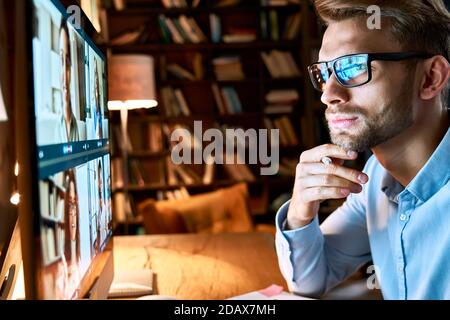 Ein Geschäftsmann, der sich den pc-Bildschirm ansieht, der online per Videokonferenz arbeitet. Stockfoto