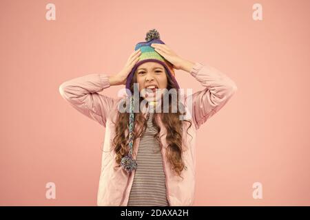 Vorbereitung für den Winter. angewidert Kind rosa Hintergrund. Kid Mode und Shopping. Mädchen. Herbst Stil. glückliche Kindheit. Kleines Mädchen winter Hut. bereit für den Winter Aktivität. warme Kleidung für die kalte Jahreszeit. Stockfoto