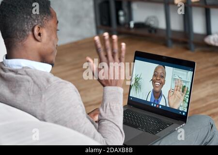 Männlicher afrikanischer Patient auf Konferenz Videoanruf mit weiblichem on-line-Arzt. Stockfoto