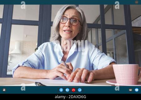Senior Business Frau im Gespräch mit der Kamera in virtuellen Videoanruf. Bildschirmansicht. Stockfoto
