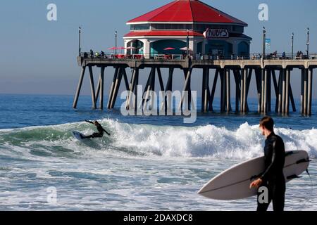 Los Angeles, Kalifornien, USA. November 2020. Ein Surfer reitet eine Welle in Huntington Beach, Kalifornien, Sonntag, 15. November 2020. Astronomische Hochtiden sind als "King Tides" bekannt und treffen die kalifornische Küste am Sonntag und Montagmorgen, und an einigen Orten bis Dienstag. Kredit: Ringo Chiu/ZUMA Wire/Alamy Live Nachrichten Stockfoto