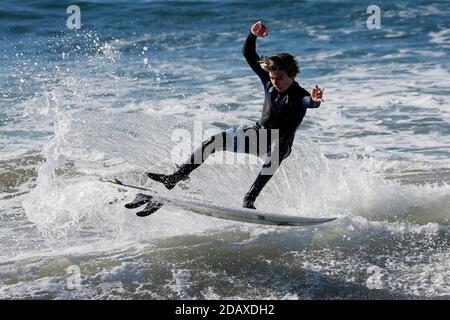 Los Angeles, Kalifornien, USA. November 2020. Ein Surfer reitet eine Welle in Huntington Beach, Kalifornien, Sonntag, 15. November 2020. Astronomische Hochtiden sind als "King Tides" bekannt und treffen die kalifornische Küste am Sonntag und Montagmorgen, und an einigen Orten bis Dienstag. Kredit: Ringo Chiu/ZUMA Wire/Alamy Live Nachrichten Stockfoto