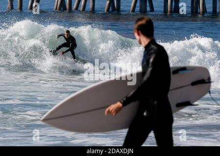 Los Angeles, Kalifornien, USA. November 2020. Ein Surfer reitet eine Welle in Huntington Beach, Kalifornien, Sonntag, 15. November 2020. Astronomische Hochtiden sind als "King Tides" bekannt und treffen die kalifornische Küste am Sonntag und Montagmorgen, und an einigen Orten bis Dienstag. Kredit: Ringo Chiu/ZUMA Wire/Alamy Live Nachrichten Stockfoto