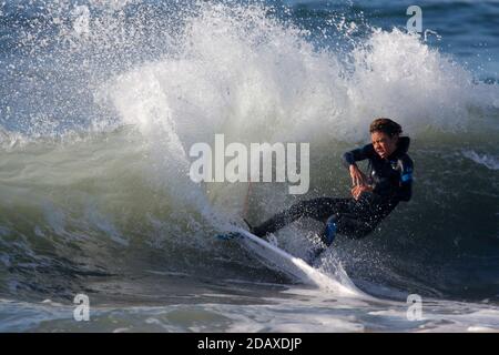 Los Angeles, Kalifornien, USA. November 2020. Ein Surfer reitet eine Welle in Huntington Beach, Kalifornien, Sonntag, 15. November 2020. Astronomische Hochtiden sind als "King Tides" bekannt und treffen die kalifornische Küste am Sonntag und Montagmorgen, und an einigen Orten bis Dienstag. Kredit: Ringo Chiu/ZUMA Wire/Alamy Live Nachrichten Stockfoto