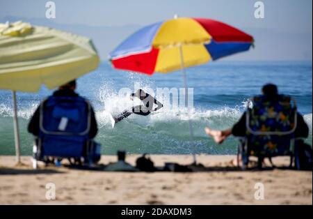 Los Angeles, Kalifornien, USA. November 2020. Ein Surfer reitet eine Welle in Huntington Beach, Kalifornien, Sonntag, 15. November 2020. Astronomische Hochtiden sind als "King Tides" bekannt und treffen die kalifornische Küste am Sonntag und Montagmorgen, und an einigen Orten bis Dienstag. Kredit: Ringo Chiu/ZUMA Wire/Alamy Live Nachrichten Stockfoto