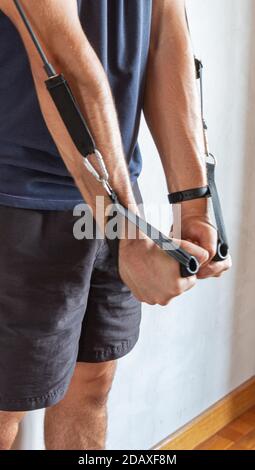 Selektiver Fokus auf die Details junger Leute, die Gymnastik machen Und Dehnübungen mit Widerstandsbändern in einem Haus Stockfoto