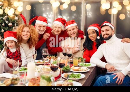 Gemischte Rennfamilie, die zusammen hinter dem Tisch sitzt Stockfoto
