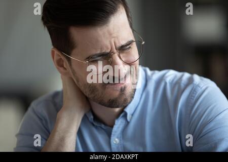 Nahaufnahme Blick runzelig Gesicht des Geschäftsmannes Schmerz im Nacken fühlend Stockfoto