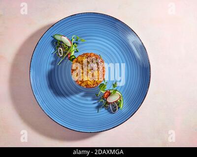 Lachs-Tartare mit goldenem Forellenkaviar auf Reisbasis mit Rettichsprossen. Stockfoto