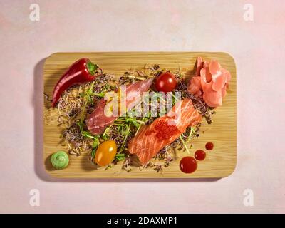 Rohe Scheiben Lachs und Thunfisch auf Rise mit goldenem und rotem Kaviar gekrönt. Stockfoto