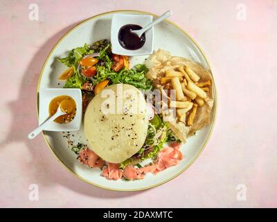 Japanischer Wagyu-Rindfleisch-Burger-Teller mit japanischen Pommes Frites und Grüns. Gohan Rise Mehl Brötchen gefüllt mit traditionellen Menchi, gebratenes rohes Hackfleisch Cov Stockfoto