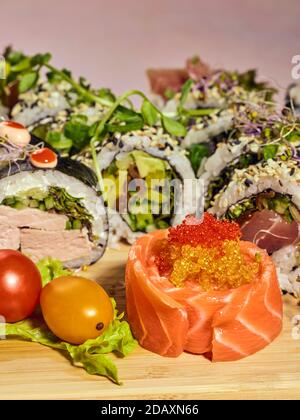 Verschiedene Sushi Maki auf dem Brett gesetzt. Roher und gebratener Lachs, Thunfisch und Garnelen. Stockfoto