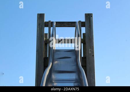 Die Vorderansicht der Oberseite eines Metallschiebers In einem Spielplatz mit niemand auf ihm als Spielplatz sind Geschlossen wegen Sperre Stockfoto