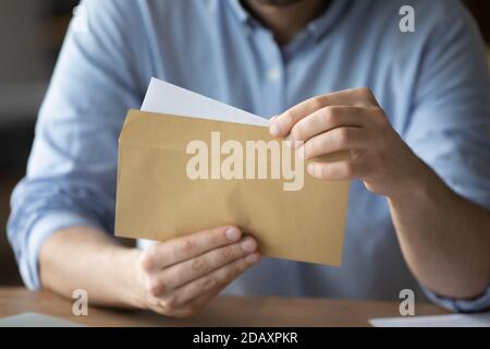 Geschäftsmann nimmt Brief aus Briefumschlag mit Business-News Stockfoto