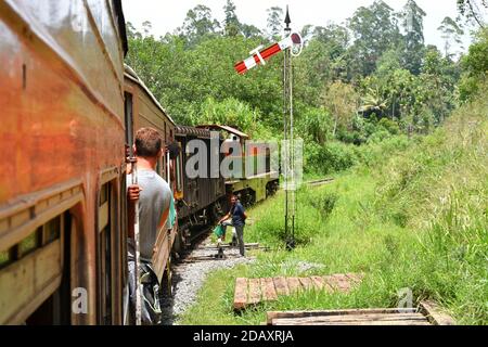 Zugfahrt in Sri Lanka. Mann, der auf einem Wagen hängt. Kandy / Sri Lanka - 12.03.2018 Stockfoto