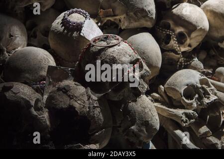 Gestapelte menschliche Schädel und Knochen auf dem Friedhof Fontanelle (Cimitero delle Fontanelle) in Neapel, Kampanien, Italien. Das ehemalige Leichenhaus (Beinhaus) in einer Höhle im Stadtteil Materdei war der Ort, an dem sich in Neapel der spontane Kult der Hingabe an die Überreste namenlos Verstorbener entwickelte. Die Verteidiger des Kults besuchten die namenlosen Schädel im Beinhaus, um sie zu adoptieren und den Schädeln sogar Namen zu geben. Adoptierte Schädel wurden in der dekorierten Box platziert und wurden zum Gegenstand des regelmäßigen Gebets und Votivopfers. Stockfoto