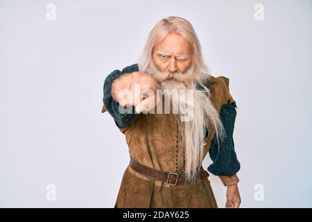 Alter älterer Mann mit grauem Haar und langem Bart trägt wikinger traditionelle Kostüm zeigt unzufrieden und frustriert auf die Kamera, wütend und wütend wi Stockfoto