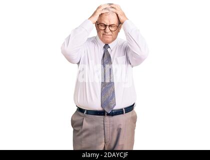 Senior grauhaarige Mann trägt Business-Kleidung leiden unter Kopfschmerzen verzweifelt und gestresst, weil Schmerzen und Migräne. Hände auf dem Kopf. Stockfoto