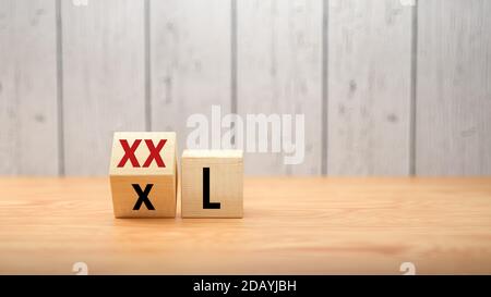 Würfel Drehen Sie die Nachricht von XXL zu XL auf Holz Hintergrund - 3d-Illustration Stockfoto