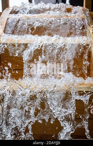 Die Rotorblätter des Mühlrades drehen sich unter einem Wasserstrom, Nahaufnahme. Stockfoto