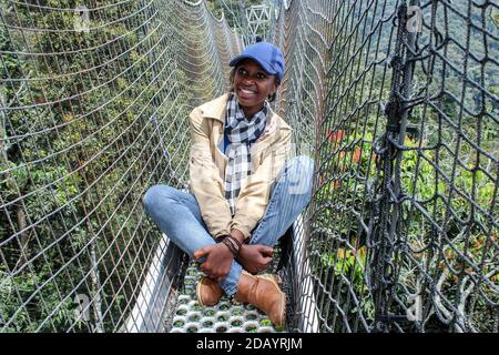 Mwaija Igiraneza, 24, liegt auf der Baldachin-Wanderung im Nyungwe-Nationalpark in Ruanda. Stockfoto