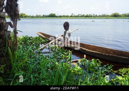 Ein kleiner Junge geht in einem Kanu auf dem Tshopo-Fluss in Kisangani, Demokratische Republik Kongo, angeln. Stockfoto