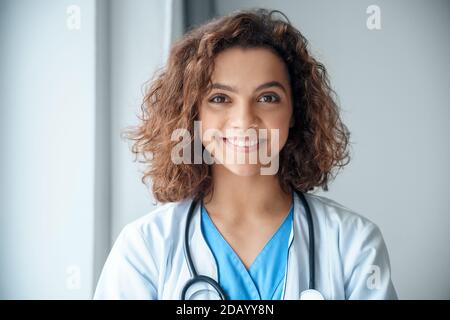 Nahaufnahme Porträt der jungen Ärztin tragen lächelnd und Blick auf die Kamera. Stockfoto