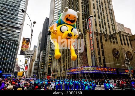 Der Finn und Jake Adventure Time Ballon bei der jährlichen Macy's Thanksgiving Day Parade entlang der Avenue of Americas mit Radio Music Hall im Hintergrund. Stockfoto