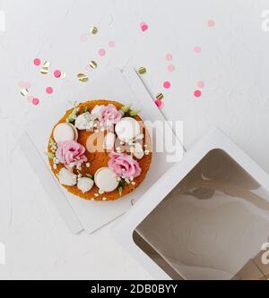 Draufsicht auf einen Honigkuchen mit Blumen auf einem Box Basis neben Fenster oben Stockfoto