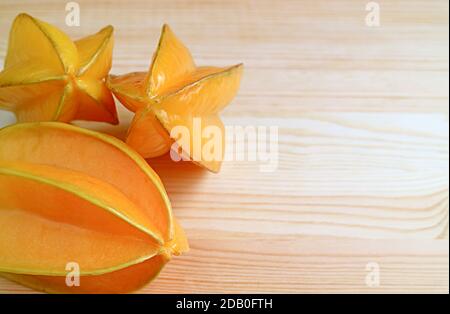 Haufen frischer reifer Carambola oder Sternfrüchte isoliert auf Holzhintergrund mit Copy Space Stockfoto