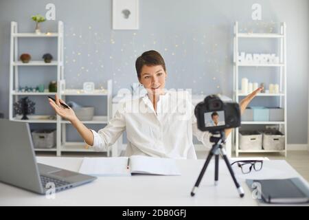 Selbstbewusste weibliche Vlogger Aufnahme Video auf Kamera sitzen bei ihr Schreibtisch in gemütlichem Home Office Stockfoto