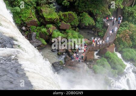 Besucher am Fuße der Bossetti Wasserfälle, Teil der Iguazu Wasserfälle im Iguazu Nationalpark auf der argentinischen Seite der Grenze zu Br Stockfoto