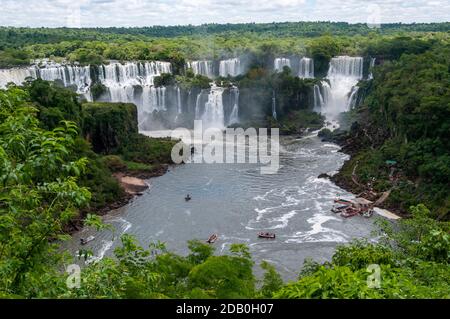 Ein Panoramablick auf die Adam & Eve Wasserfälle und Bossetti Wasserfall (rechts) von der brasilianischen Seite der Iguazu Wasserfälle. Unten ist eine kleine Flucht Stockfoto